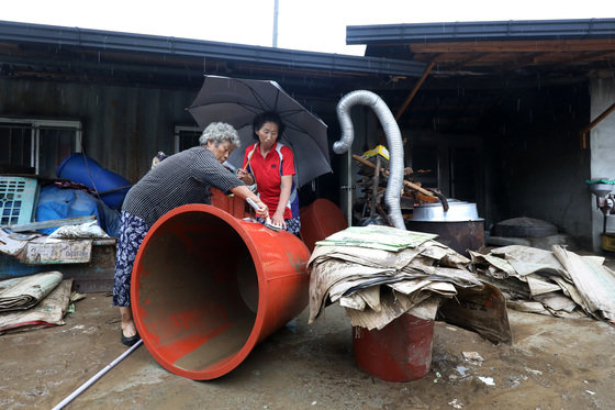 18일 경북 예천군 용문면 사부2리에서 주민이 가재도구에 쌓인 토사를 씻어내고 있다. 이 마을에서는 지난 15일 새벽 집중호우와 산사태로 2명이 숨졌다. 2023.7.18/뉴스1