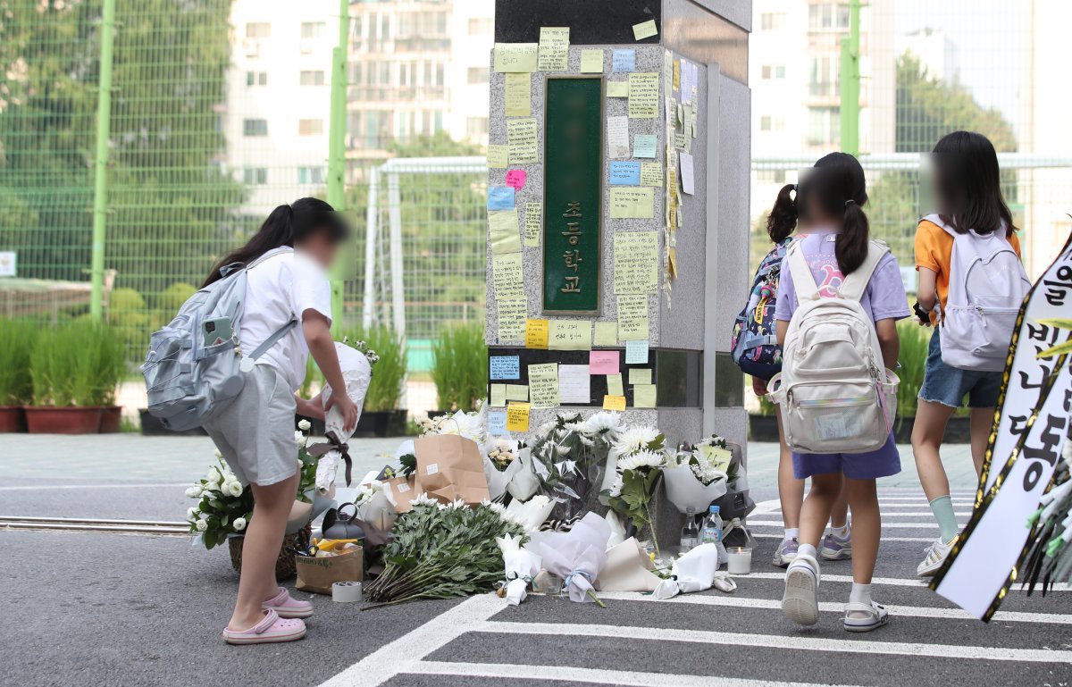 20일 오전 서울 서초구의 한 초등학교에서 한 학생이 정문에 꽃을 놓고 있다. 서울시교육청 등에 따르면, 지난 18일 오전 이 학교 1학년 담임인 A 씨(23)가 극단적인 선택으로 사망하는 일이 발생했다. 2023.7.20/뉴스1