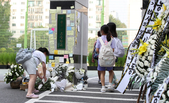 20일 오전 서울 서초구의 한 초등학교에서 학생이 정문에 꽃을 놓고 있다. 서울시교육청 등에 따르면, 지난 18일 오전 이 학교 1학년 담임인 A씨(23)가 극단적인 선택으로 사망하는 일이 발생했다. ⓒ News1