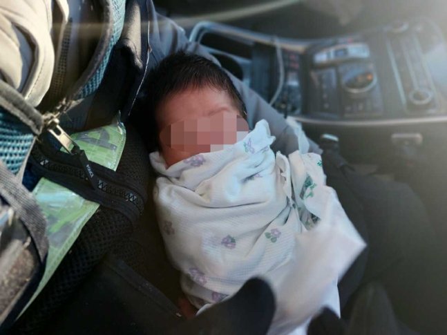 20일 오후 갓난아이를 발견한 경찰관이 순찰차에서 아이를 안고 있다. (사진=강원도소방본부 제공). 뉴시스
