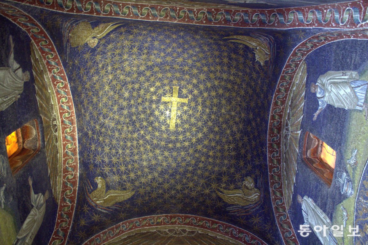 이탈리아 라벤나에 있는 ‘갈라 플라키디아 영묘’의 천장. 5세기 초 로마 황제의 여동생이었던 갈라 플라키디아가 조성한 것으로 전해진다. 푸른 청금석에 금빛 유리 조각을 붙인 천장은 어두운 밤하늘을 별빛으로 밝히는 십자가를 상징적으로 보여준다. 까치 제공
