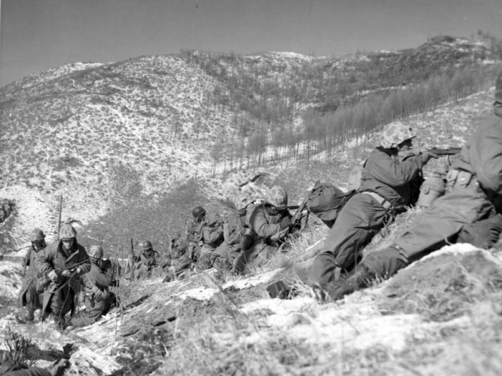 장진호 전투에 참가한 미군들이 눈덮인 상중턱에 엎드려 전투를 하고 있다.