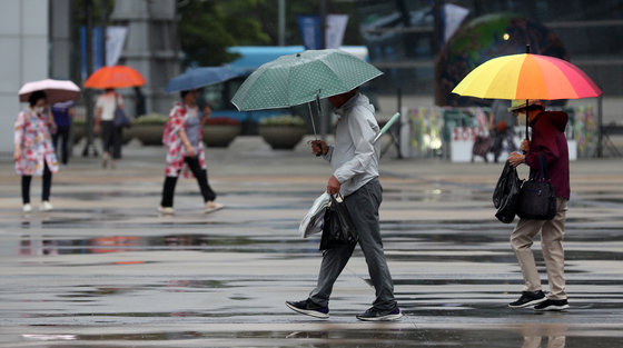 부산지역에 비가 내리는 지난 11일 오후 부산 해운대구 벡스코 광장에서 우산을 쓴 시민들이 이동하고 있다. 2023.7.11 뉴스1