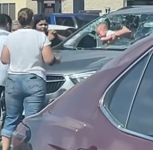 텍사스 남부 할링겐의 한 아울렛 주차장에서 한 남성이 차량에 갇힌 아이를 구하기 위해 유리창을 깨는 모습.(폭스뉴스 갈무리).