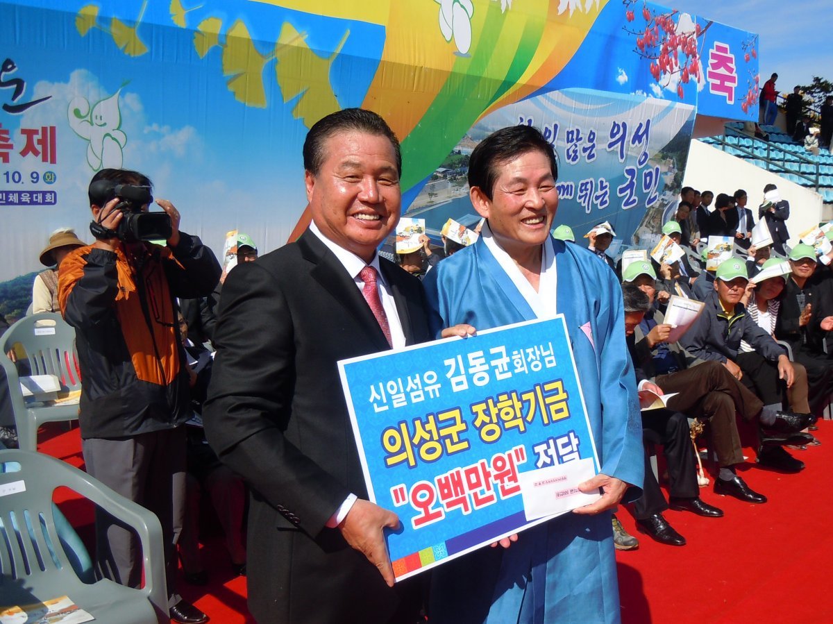 의성군에 장학기금을 전달하는 김동균 신일염공 회장(왼쪽).
