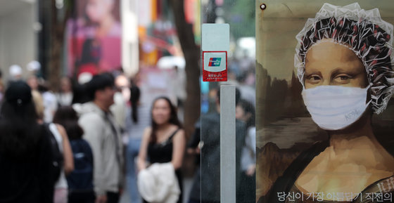 10일 서울 중구 명동거리의 한 헤어샵 광고에 마스크가 보이고 있다. 2023.5.10/뉴스1
