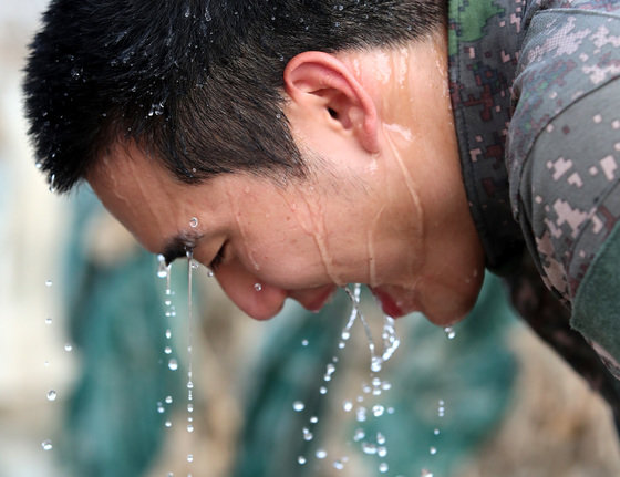 전국적으로 폭염으로 무더운 날씨를 보인 27일 오후 충남 청양 청남면 인양리에서 집중호우 피해 복구작전에 투입된 육군 32사단 장병들이 물을 뿌리며 더위를 식히고 있다. 2023.7.27/뉴스1