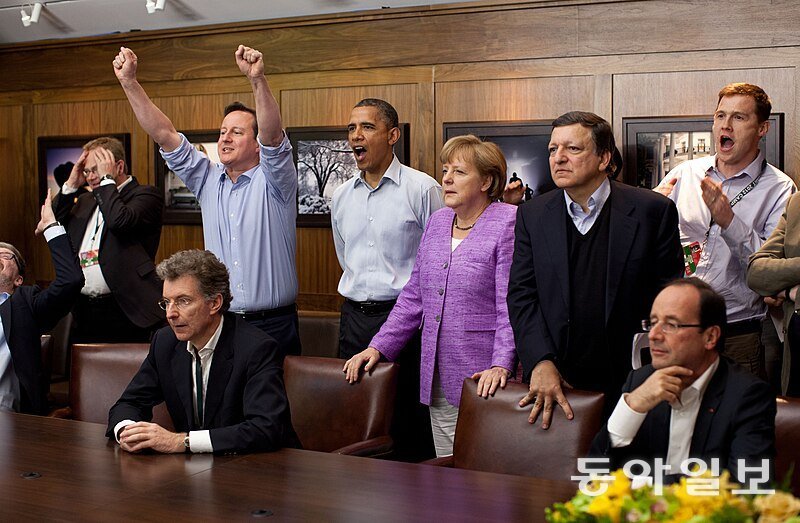 2012년 캠프 데이비드에서 열린 주요8개국(G8) 정상회담 때 축구 경기를 관람하는 정상들. 왼쪽부터 손을 들고 환호하는 데이비드 캐머런 영국 총리, 버락 오바마 미국 대통령, 심각한 표정의 앙겔라 메르켈 독일 총리, 호세 마누엘 바로소 EU 집행위원장, 앞쪽에 앉아있는 프랑수와 올랑드 프랑스 대통령. 위키피디아