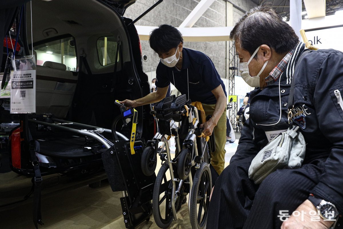 휠체어를 탄 한 노인이 ‘휠체어 이동’ 장치를 구경하고 있다. 전동 휠체어를 힘을 들이지 않고 차에 싣기 위해 개발된 장치로 버튼을 누르면 휠체어 고정 장치가 트렁크 밖으로 나와 편하게 싣거나 내릴 수 있다.