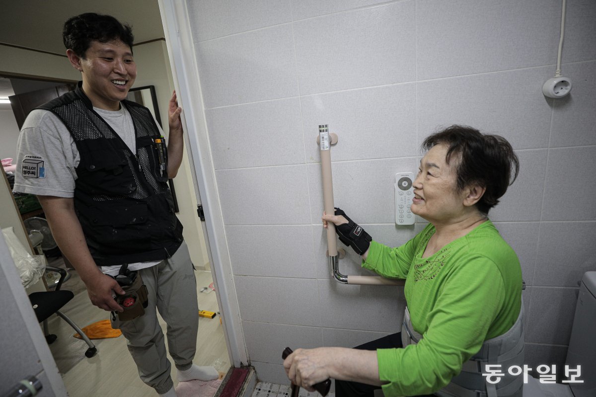 지난달 20일 서울 성북구의 김쌍례 할머니 집을 찾은 김진구 씨(왼쪽).  김 씨와 직원들은  무릎, 허리, 손목 등의 통증을 겪는 할머니가 화장실에서 넘어지지 않도록 변기 옆에 ‘안전손잡이’를 설치했다.