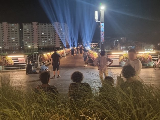 강원 강릉지역에 5일 연속 열대야 현상이 나타난 27일 강릉시 월화교를 찾은 시민들이 야간 조명을 감상하며 무더위를 식히고 있다. 2023.7.27/뉴스1