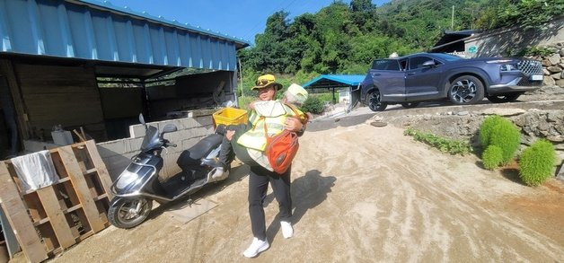 지난달 31일 오전 9시10분쯤 함양군 별곡면 망월마을회관 인근 도로를 순찰하던 우리동네파수꾼이 폭염에 지쳐 쓰러져 있는 주민을 구조하고 있다.(경남도자치경찰위 제공)