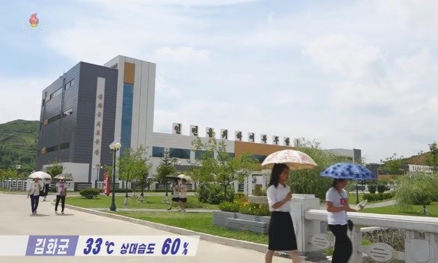 연일 계속된 폭염에 북한 주민들이 양산을 들고 길을 걷고 있다.  (조선중앙TV 갈무리)