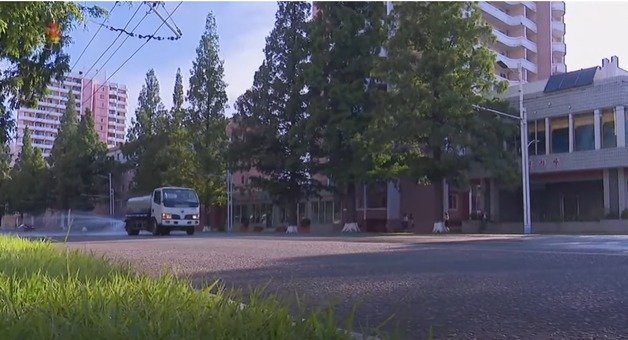 폭염에 살수차가 물을 뿌리며 도로열을 식히고 있다. (조선중앙TV 갈무리)