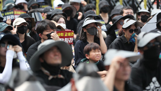 서울 종로구 정부서울청사 인근 도로에서 지난 7월29일 열린 서이초 교사 추모식 및 교사생존권을 위한 집회에서 참가자들이 추모 영상을 보며 흐르는 눈물을 닦고 있다. 2023.7.29/뉴스1
