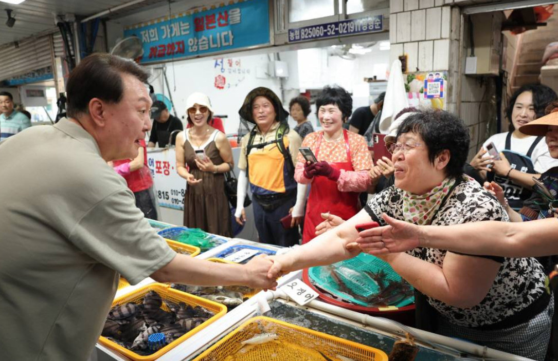 윤석열 대통령이 4일 경남 거제 고현종합시장을 방문해 상인들과 인사를 니누고 있다. 대통령실 제공