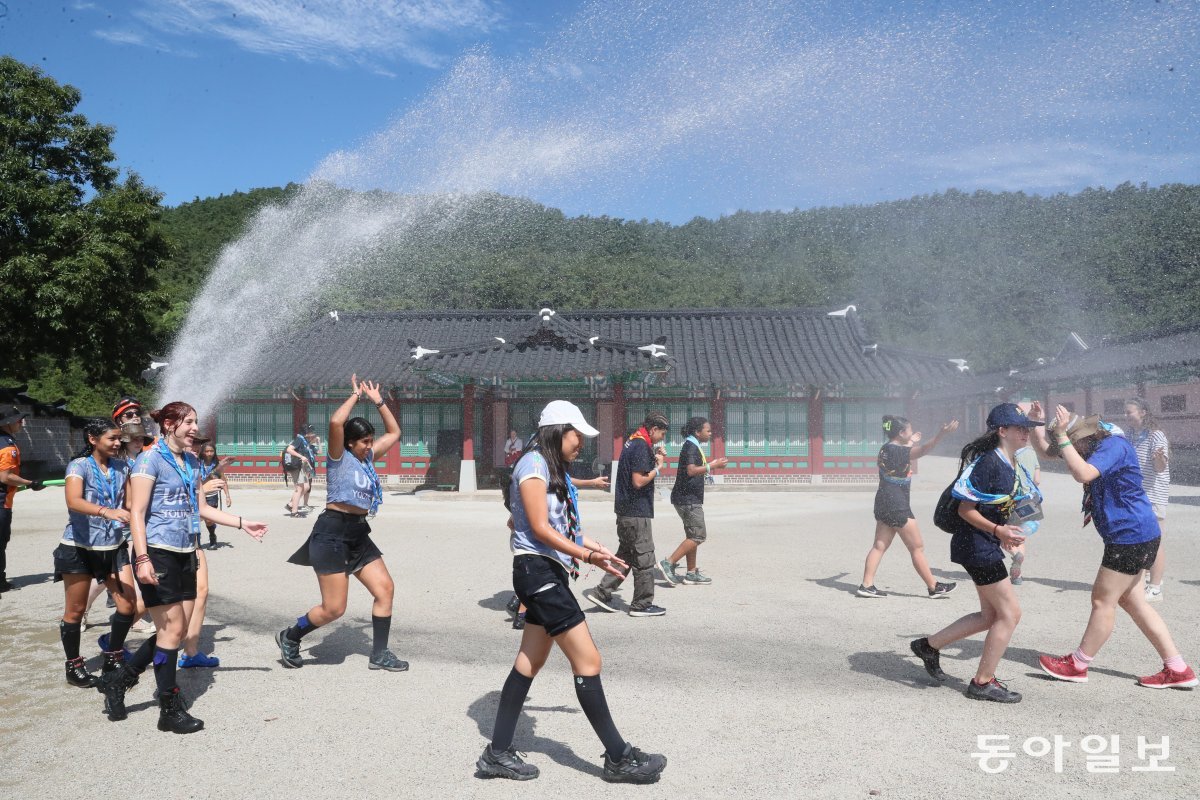 부안영상테마파크를 찾은 학생들의 더위를 식혀주기 위해 자원봉사자들이 물을 뿌려주고 있다