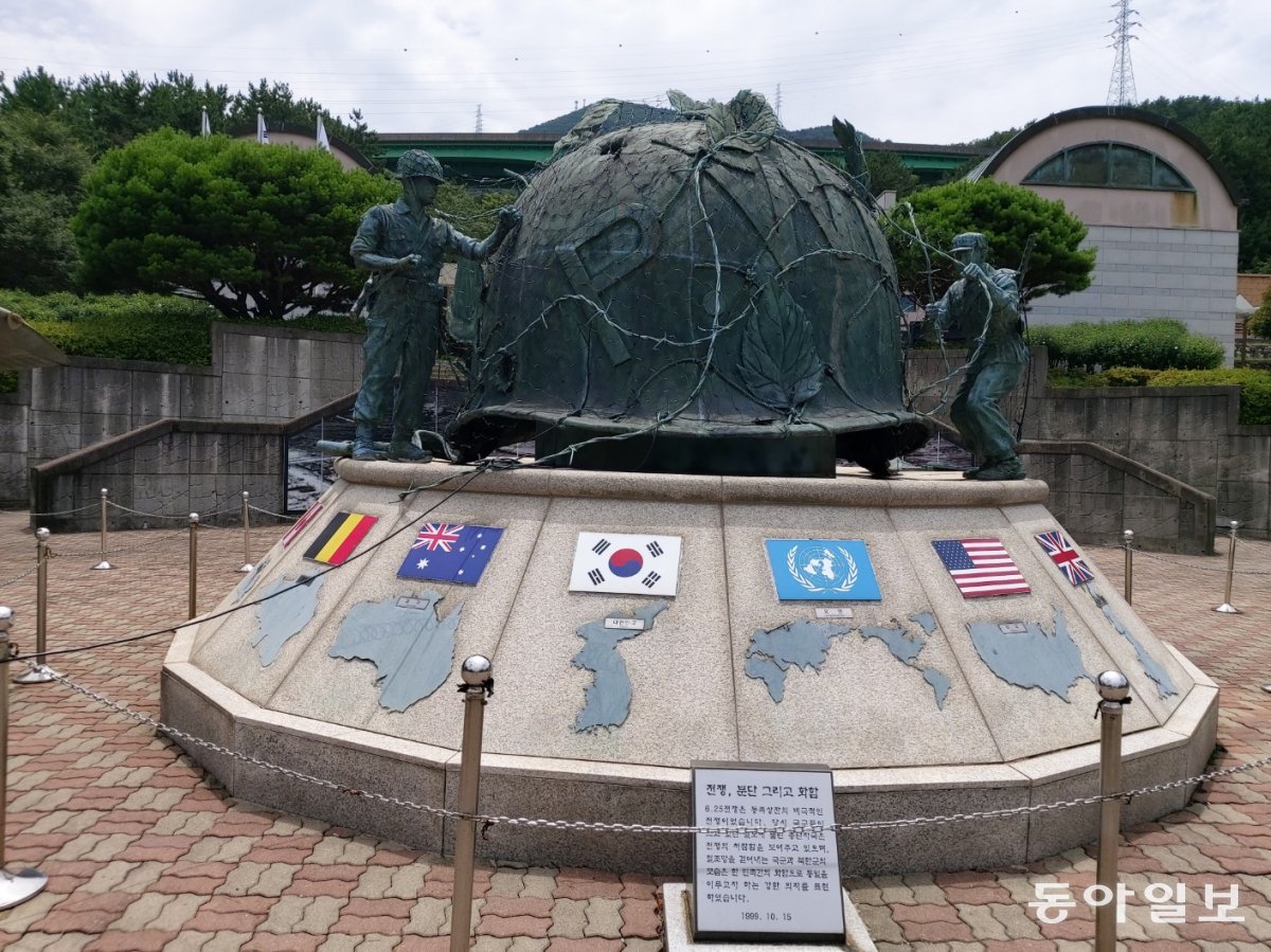 경남 거제의 포로수용소 유적공원에 유엔군 참전국 국기와 철모 조형물. 국군과 북한군이 철조망을 함께 걷어내 화합과 통일을 기원하는 마음을 담았다는 설명이 붙어있다. 거제 = 구자룡 기자