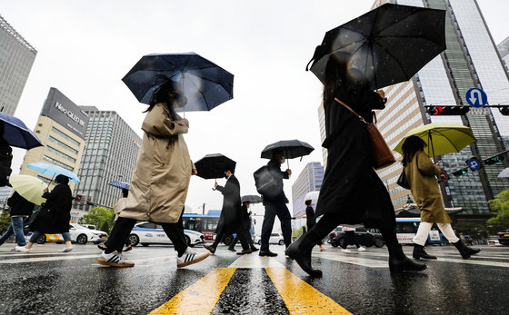 보슬비가 내리는 18일 서울 광화문 사거리에 우산을 쓴 시민들이 출근길 발걸음을 옮기고 있다. 2023.4.18. 뉴스1