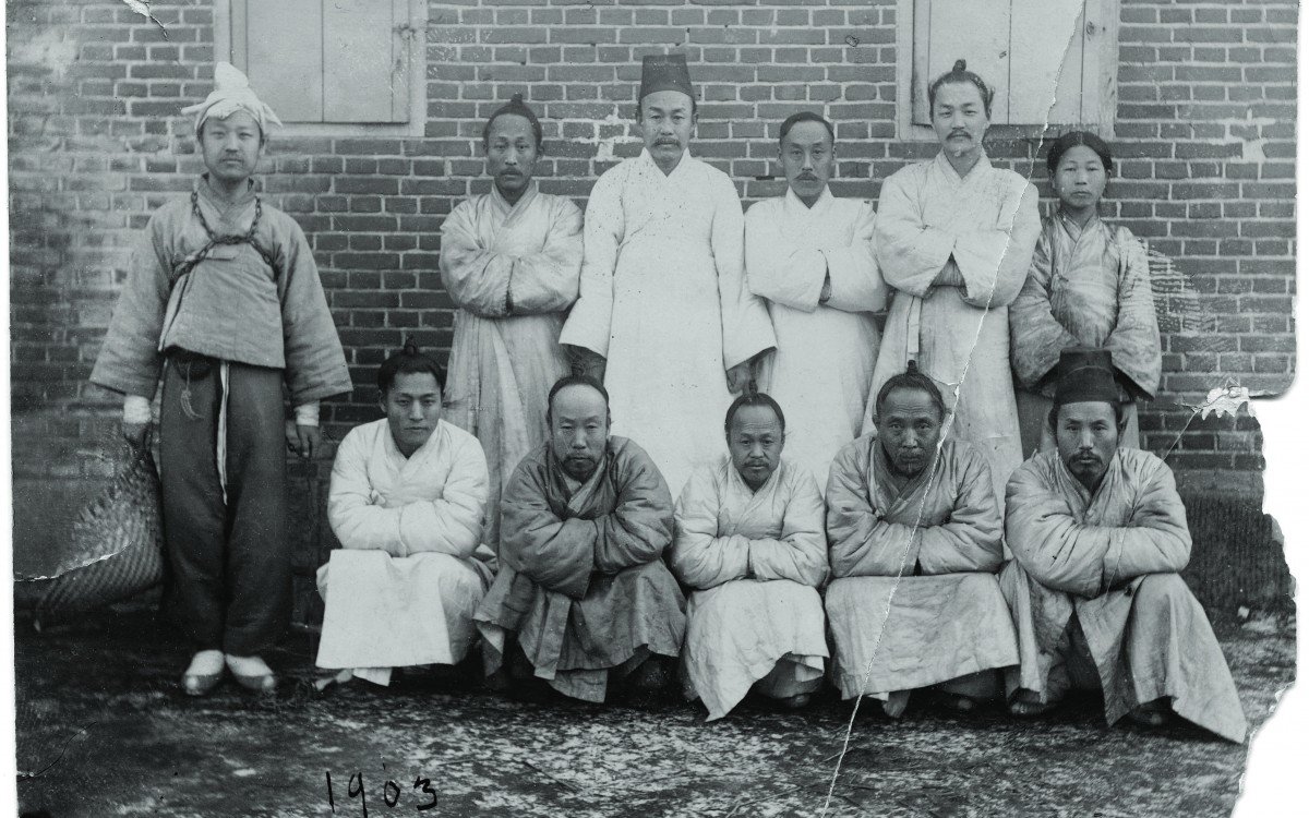 1903년 대한제국 한성감옥에 수감된 죄수복 차림의 이승만(가장 왼쪽에 서있는 사람)과 이상재(앞줄 오른쪽에서 두 번째). 당시 이승만은 28세였다.  이승만건국대통령기념사업회