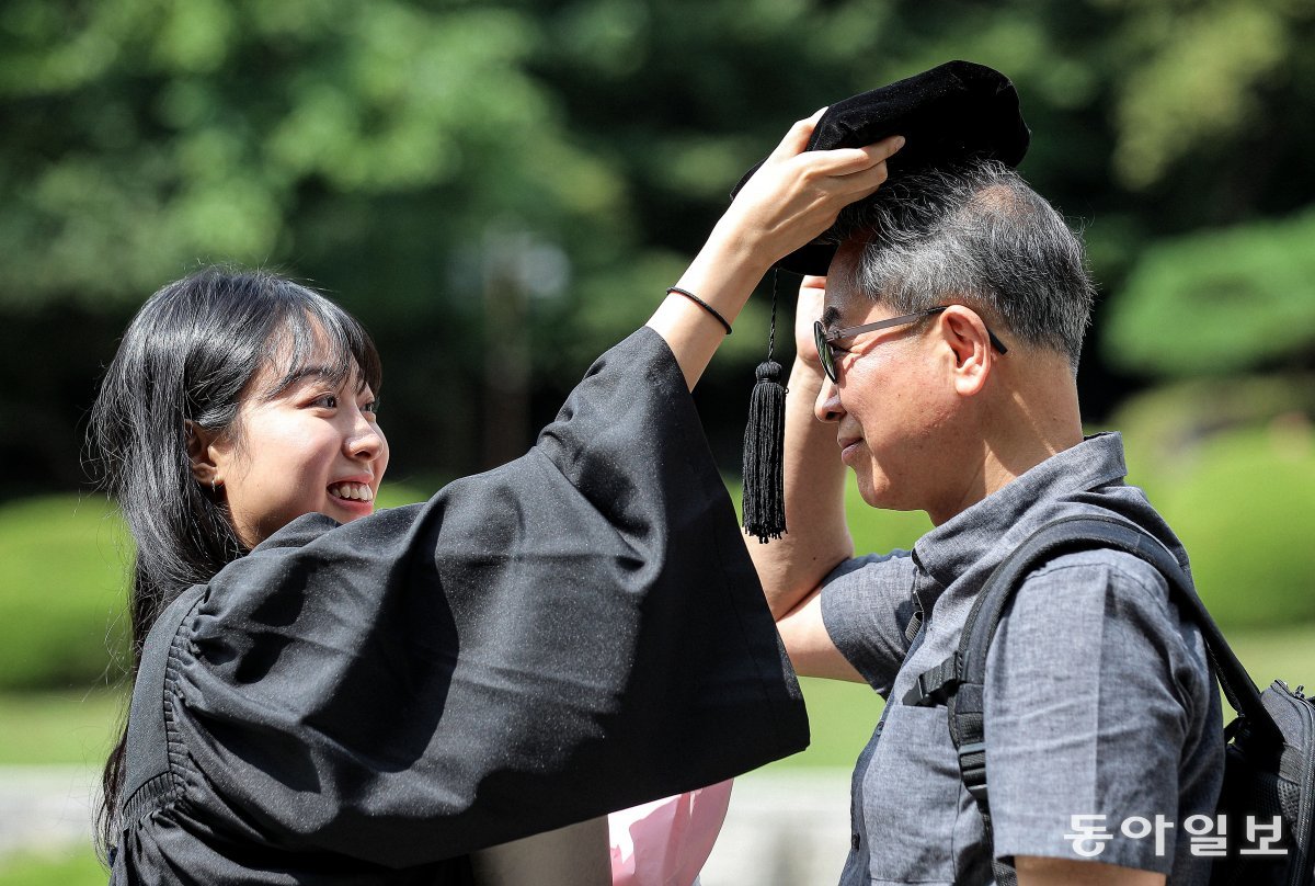 16일 오후 후기 학위수여식이 열린 서울 경희대학교에서 한 졸업생이 아버지에게 학사모를 씌워주고 있다. 송은석기자 silverstone@donga.com