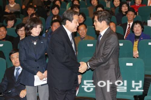 새누리당 김무성 대표와 김문수 보수혁신위원장이 2014년 11월 서울 여의도 국회도서관 대강당에서 열린 새누리당 서울시당 핵심당원연수에 참석해 악수하고 있다. 동아일보 DB