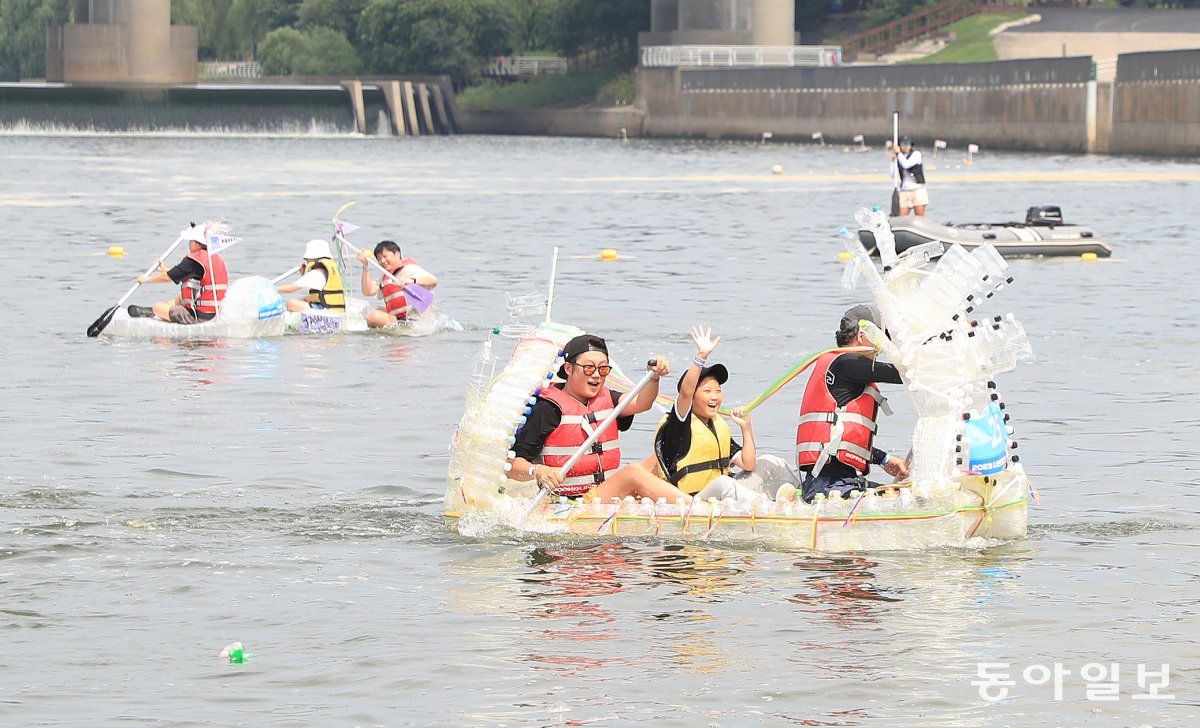 20일 서울 송파구 잠실한강공원에서 재활용 소재를 활용해 나만의 ‘배’를 만들어 한강을 돌아오는 ‘나만의 한강호 경주대회’가 열렸다. 참가자들이 힘차게 노를 젓고 있다. 2023 한강 페스티벌 여름 프로그램의 하나로 진행됐다.  김재명 기자 base@donga.com