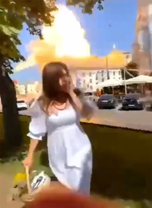 토요일인 19일 우크라이나 북부 도시 체르니히우 중앙광장 인근에서 하얀 드레스 차림의 여성이 사진 촬영을 위해 카메라 쪽을 바라보다가 러시아군이 쏜 미사일이 등 뒤에서 폭발하자 깜짝 놀라고 있다. 사진 출처 트위터