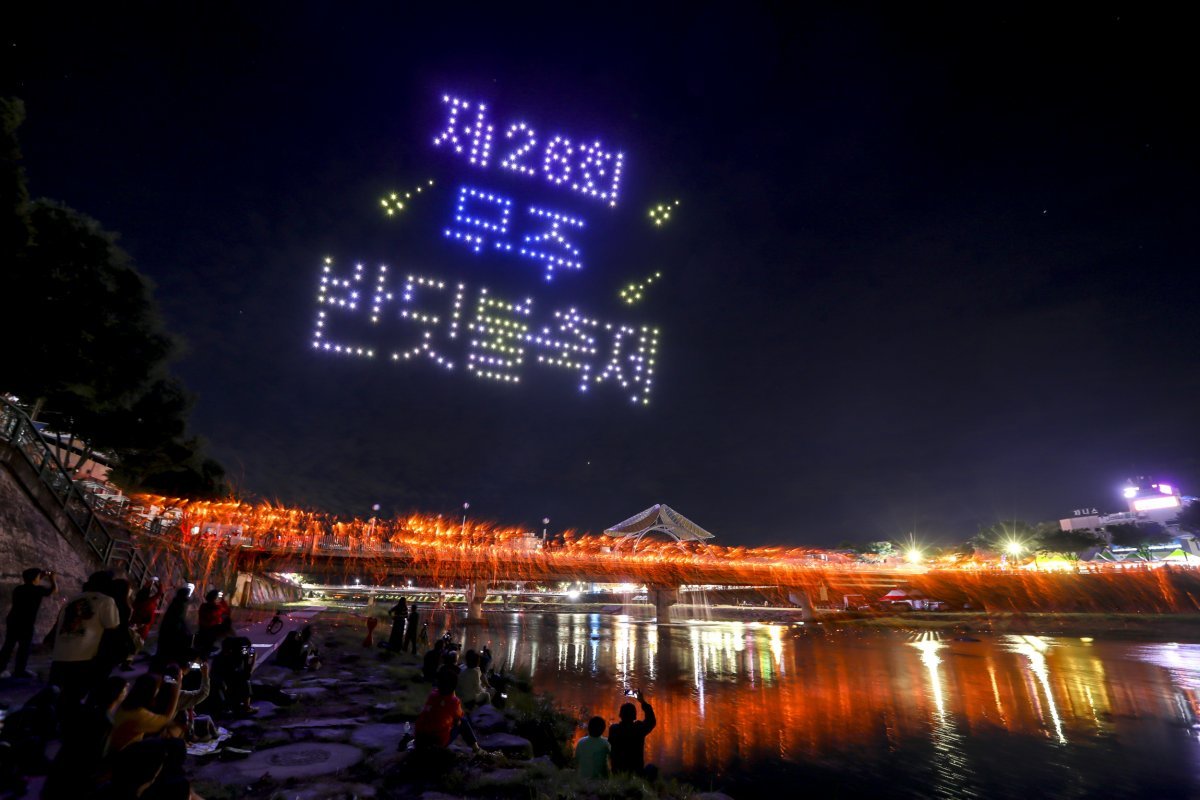 축제 참가자들이 전북도 무형문화재 ‘무주 안성 낙화놀이’와 ‘드론쇼’를 관람하고 있다. 무주군 제공