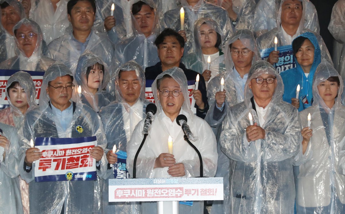 더불어민주당 이재명 대표가 23일 밤 국회 본청 앞 계단에서 열린 후쿠시마 원전 오염수 해양투기 철회 촉구 촛불집회에서 발언하고 있다. 이날 민주당 지도부와 의원, 당직자, 지지자 등은 빗 속에서 우의를 입은 채 촛불집회를 진행했다. 뉴스1