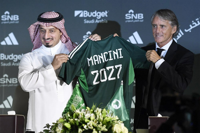 이탈리아 출신 로베르토 만치니 감독(오른쪽)이 사우디아라비아 축구대표팀 지휘봉을 잡았다. 만치니 감독이 29일 부임 기자회견에서 
자신의 이름과 숫자 ‘2027’이 적힌 사우디 대표팀 유니폼을 들어 보였다. 그의 계약기간이 2027년까지다. 리야드=AP 뉴시스