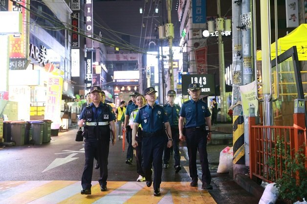 홍기현 경기남부경찰청장(사진 앞줄 가운데)이 경찰 간부 및 민·관과 함께 수원시 인계동 일대 번화가를 순찰하고 있다.(경기남부경찰청 제공)