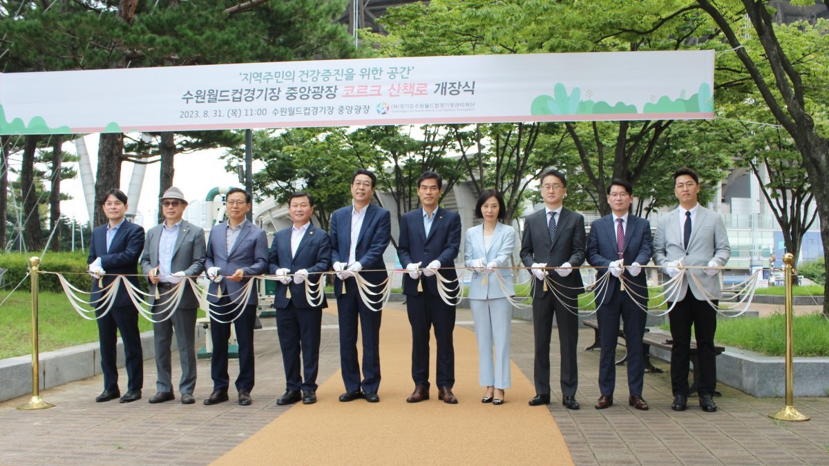 이민주 (재)경기도수원월드컵경기장관리재단 사무총장(왼쪽에서 여섯번 째)이 김기배 팔달구청장(왼쪽에서 다섯번째) 등 내빈과 함께 코르크 친환경 산책로 개장에 앞서 테이프커팅을 하고 있다. 경기도수원월드컵경기장관리재단 제공