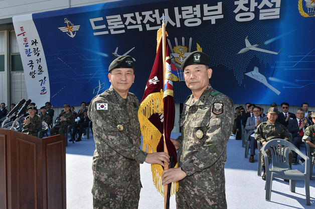 1일 개최된 드론작전사령부 창설식에서 김승겸 합참의장(왼쪽)이 초대 드론작전사령관 이보형 소장(오른쪽)에게 부대기를 수여하고 있다.(합참 제공)