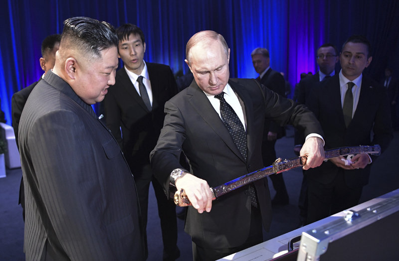 푸틴 러시아 대통령이 2019년 4월 25일 블라디보스토크에서 열린 정상회담에서 김정은 북한 국무위원장에게 선물 받은 검(劍)을 꺼내 보이고 있다. 블라디보스토크=AP 뉴시스