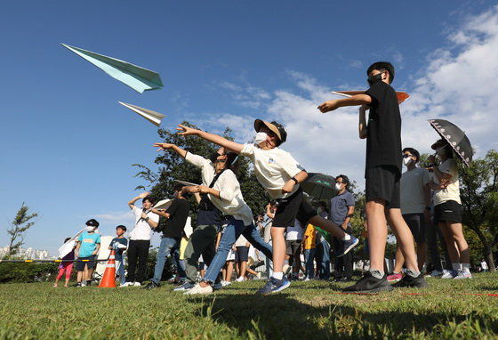 서울 영등포구 여의도한강공원 잔디마당에서 지난해 9월 열린 ‘2022 한강 종이비행기 축제’에 참가한 가족들이 점보 종이비행기 예선전을 치르고 있다. 뉴스1