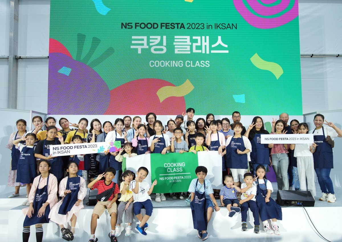 16일 전북 익산시 함열읍에서 열린 ‘NS 푸드페스타 2023 in 익산’의 쿠킹클래스에 참가한 이주여성과 그 가족들이 요리 강연에 이어 진행된 기념 촬영에서 미소를 짓고 있다. 하림 제공