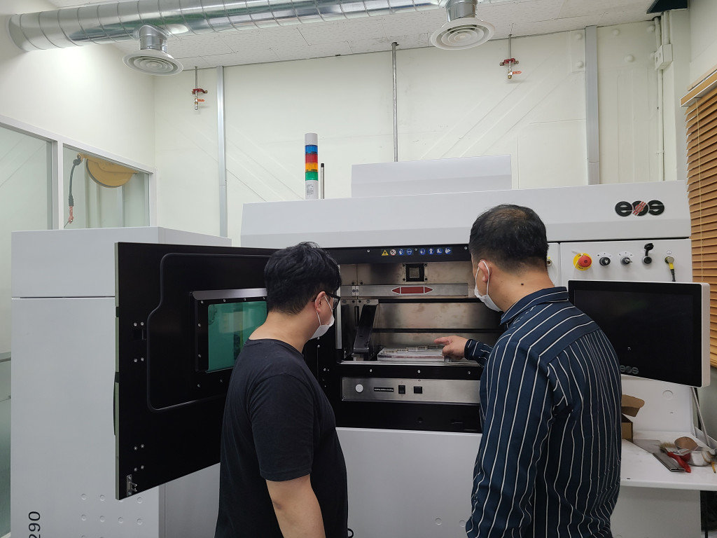 이정필 매니저(우)와 최태호 매니저(좌)가 금속 3D프린터를 살펴보고 있다 / 출처=IT동아