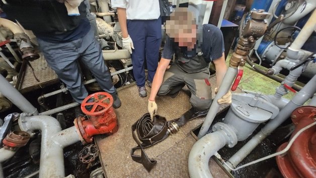 러시아 기관사가 빌지 불법 배출에 사용한 바이패스호스를 가리키고 있다. 부산해경 제공