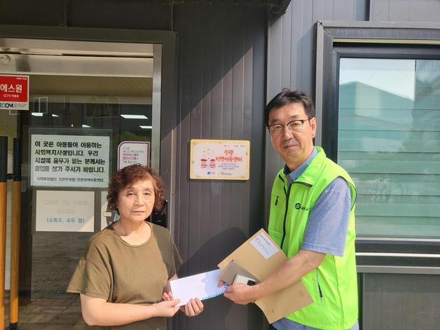 지난달 14일 김창동 구파발역 역장(오른쪽)이 서울 지하철 3호선 구파발역 인근 진관아동지역센터를 방문해 유실자가 남기고 간 50만원을 기부하고 기념촬영을 하고 있다. (서울교통공사 제공)