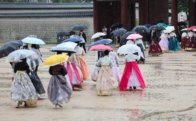 가을비가 내리는 20일 서울 종로구 경복궁을 찾은 관람객들이 우산을 쓰고 이동하고 있다. 2023.9.20/뉴스1