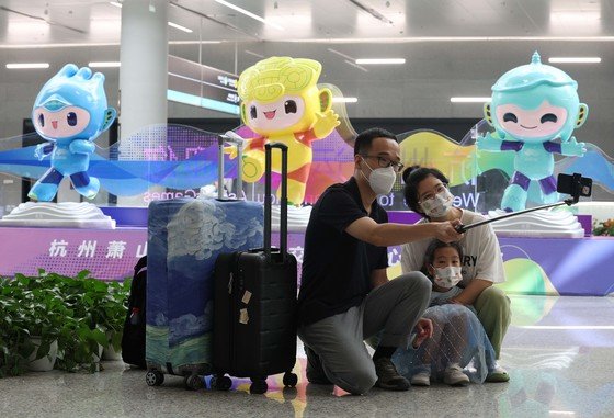 18일 오후 중국 항저우 샤오산 국제공항에서 한 가족이 항저우 아시안게임 마스코트 천천, 롄롄, 충충 앞에서 기념 촬영을 하고 있다. 2023.9.18 뉴스1