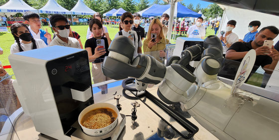 지난해 8월 27일부터 이틀간 구미낙동강체육공원 구미캠핑장에서 열리는 ‘라면캠핑페스티벌’에 참가한 외국인들이 라면끓이는 로봇을 신기하게 바라보고 있다. 2022.8.27/뉴스1 ⓒ News1