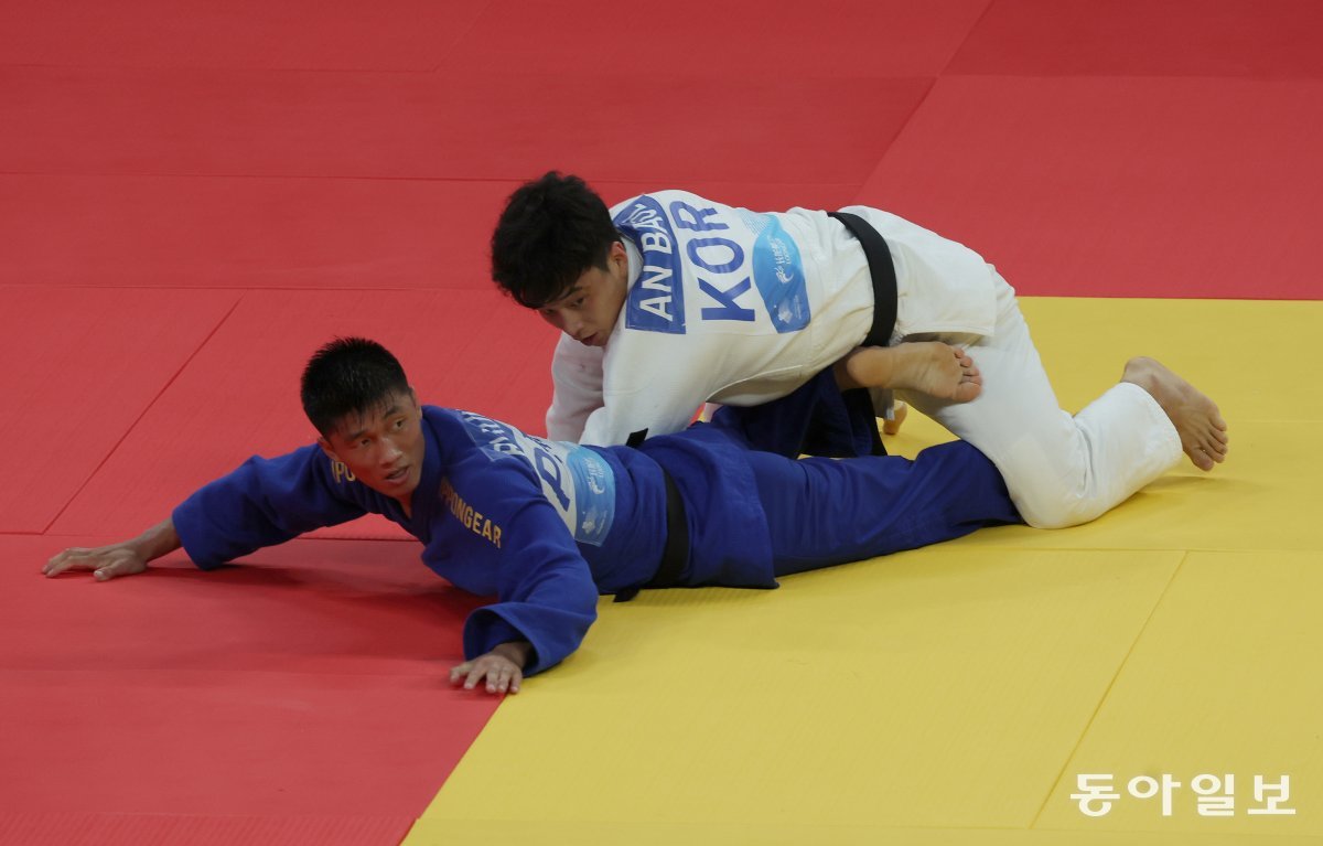 대한민국의 안바울 선수가 북한의 리금성 선수와 16강전에서 안뒤축감아치기를 시도해 절반을 얻어 승리했다. 두 선수가 심판을 바라보고 있다. 항저우=김재명 기자 base@donga.com