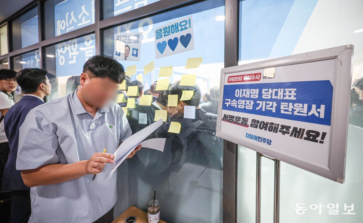 24일 더불어민주당 관계자가 민주당 지지자들에게 나눠줄 탄원서를 정리하고 있다. 박형기 기자 oneshot@donga.com