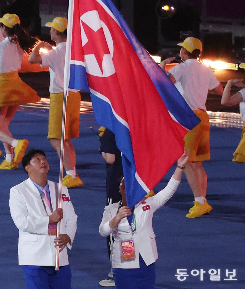 북한 선수단 기수 박명원(왼쪽)과 방철미가 23일 항저우 아시안게임 개회식에서 인공기를 들고 입장하고 있다. 항저우=김재명 기자 base@donga.com