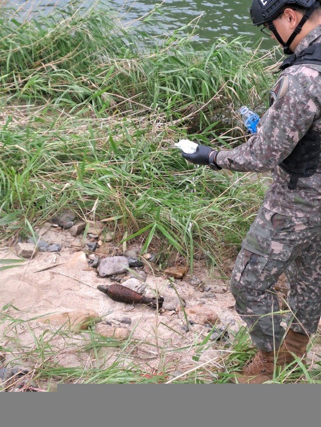 25일 오전 육군 폭발물처리반 관계자가  충북 옥천군 옥천읍 옥각리 인근 서화천에서 수거한 폭탄을 조사 중이다. (옥천소방서 제공)