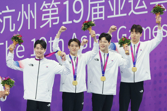25일 오후 중국 항저우 올림픽 스포츠센터 수영장에서 열린 남자 계영 800ｍ 결승전에서 1위를 차지한 대한민국 황선우(왼쪽부터) 김우민, 이호준, 양재훈이 금메달을 목에 걸고 시상대에 올라 포즈를 취하고 있다. 2023.9.25 뉴스1