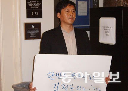 2005년 워싱턴에서 한성렬 북한 유엔대표부 차석대표 면전에서 김정일을 타도하라는 구호를 들고 시위하는 김성민 대표.