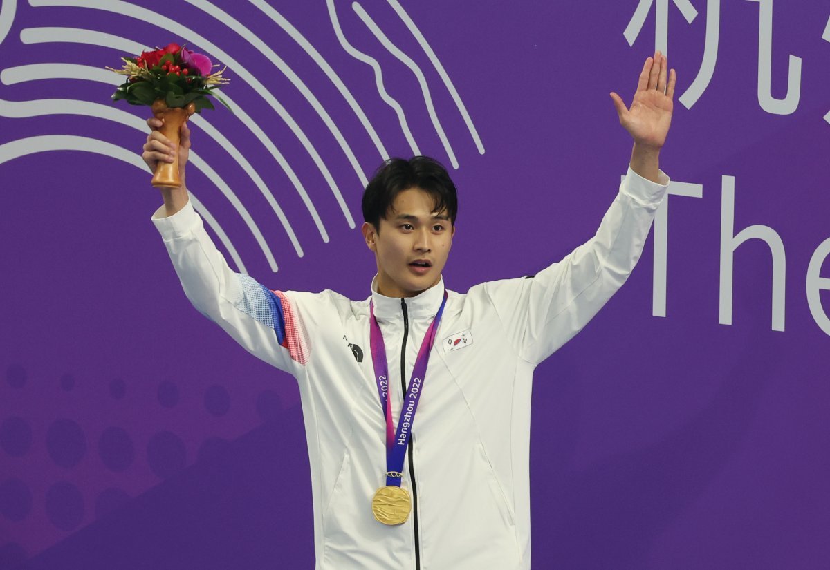 백인철이 28일 중국 항저우 올림픽 스포츠센터에서 열린 항저우 아시안게임 수영 남자 접영 50m에서 우승한 뒤 시상식에서 금메달을 목에 걸고 손을 들어 인사하고 있다. 항저우=뉴시스